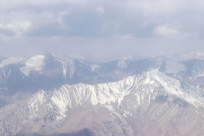 Aerial view of snowcapped mountains against sky