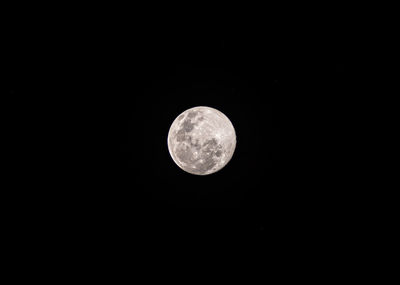 Low angle view of full moon against dark sky