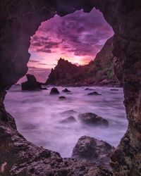 Rock formations in sea against sky during sunset