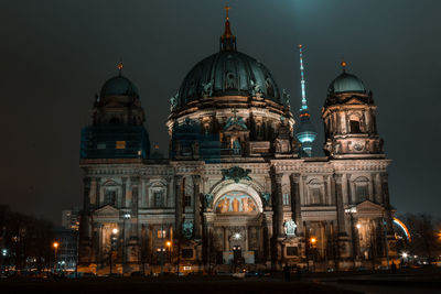 Illuminated building against sky at night