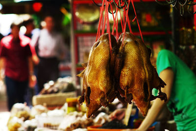 Chinese style peking roast duck hanging for sale at a sidewalk food stall in china town