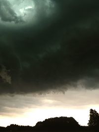 Silhouette of trees against cloudy sky