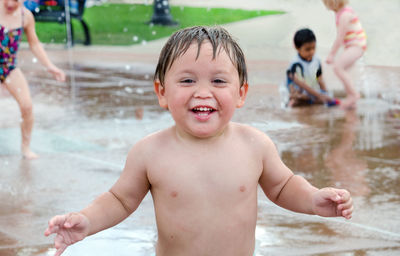 Happy summer child playing in a urban splash pad