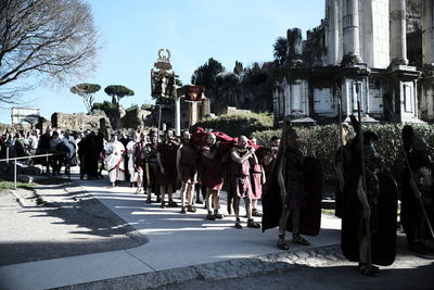 People on street amidst buildings in city