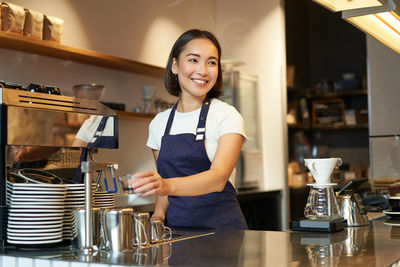 Portrait of young woman standing in cafe