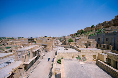 High angle view of buildings against clear blue sky