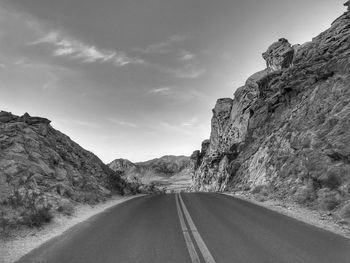 Road amidst rock formation against sky