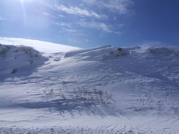 Snow covered land against sky