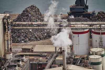 High angle view of smoke emitting from factory at recycling center at harbor, barcelona 