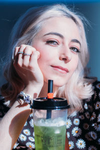 Close-up portrait of a young woman drinking glass