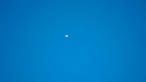 Low angle view of moon against blue sky