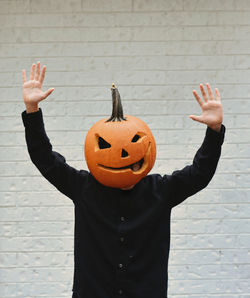 Person having fun with a carved pumpkin head