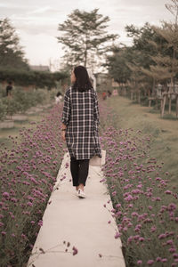 Rear view of woman walking on footpath