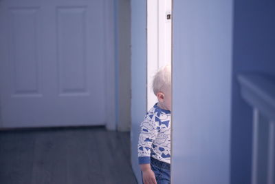 Cute girl standing at entrance of home