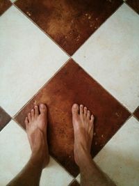 Low section of woman standing on tiled floor