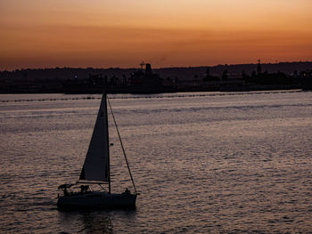 Silhouette sailboat on sea against sky during sunset