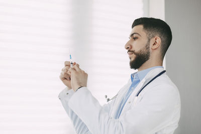 The doctor prepares for the injection with a syringe. medical concept