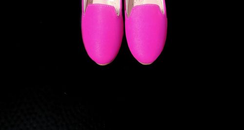 High angle view of pink shoes over black background