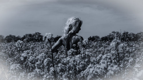 Side view of woman on field against sky