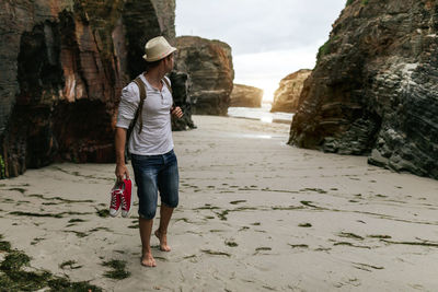 Full length rear view of woman walking on beach