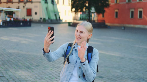 Young woman using mobile phone in city