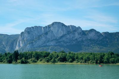 Scenic view of river by mountains against sky