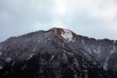 Low angle view of snowcapped mountains against sky