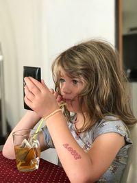 Midsection of a boy drinking water from mobile phone