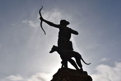 Low angle view of silhouette statue against sky