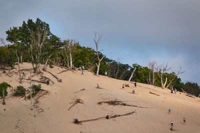 People at beach against sky