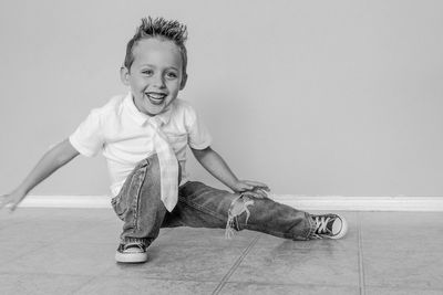 Cheerful young boy in a breakdance posture on the floor