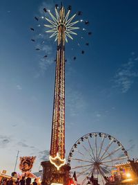 Low angle view of chain carousel against sky