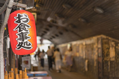 Close-up of lantern hanging on wooden wall