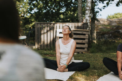 Woman practicing yoga in garden