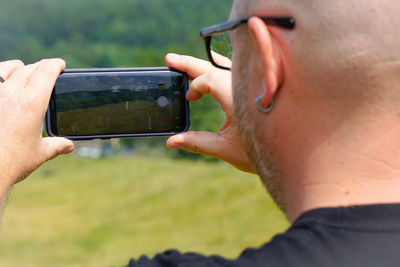 Close-up of man photographing with mobile phone