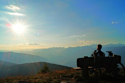 Silhouette people on mountain against sky