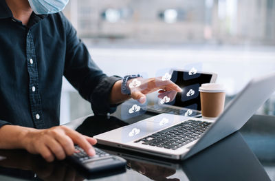 Midsection of woman using laptop on table