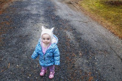 High angle portrait of cute baby girl standing on road