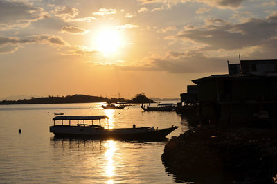 Boats in sea at sunset