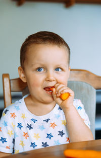 Portrait of cute boy eating food at home