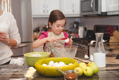 Girl holding vegetables in kitchen