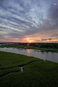 Scenic view of agricultural field against sky during sunset