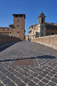View of old building in town against blue sky