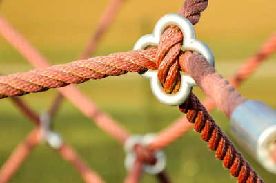 Close-up of rope tied to metal fence