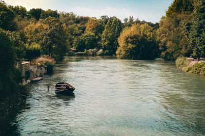 Scenic view of river amidst trees against sky