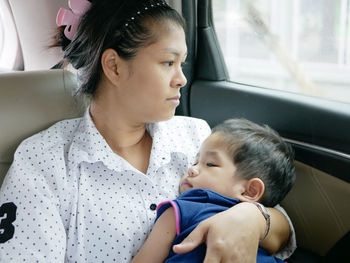 Mother with cute son sitting in car