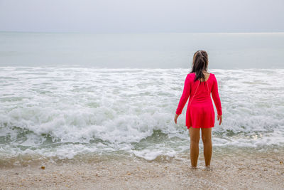 Rear view of woman standing on beach