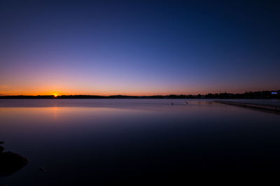 Scenic view of sea against clear sky at sunset