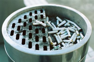 Close-up of cigarette butts in container 