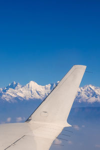 Scenic view of snowcapped mountains against clear blue sky